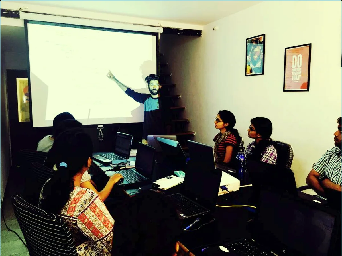 A class in progress at the training institute — a session at the projector, students at their laptops